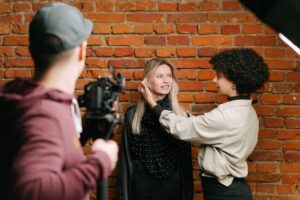 Diverse team at photoshoot setting up against a brick wall. Capturing fashion and style behind the scenes.